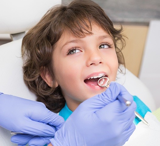 Dentist checking child's tooth colored fillings