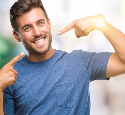 man pointing to his smile with straight white teeth 
